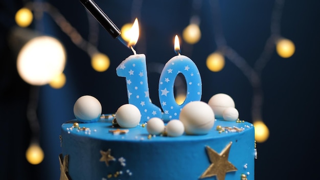 Torta di compleanno numero 10 stelle cielo e luna concetto, candela blu è fuoco di accendino. Copia lo spazio sul lato destro dello schermo. Avvicinamento