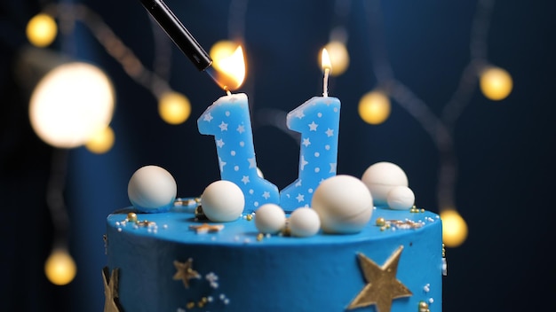 Torta di compleanno numero 11 stelle cielo e luna concetto, candela blu è fuoco di accendino. Copia spazio sul lato destro dello schermo. Avvicinamento