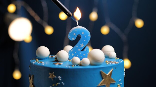 Torta di compleanno numero 2 stelle cielo e luna concetto, candela blu è fuoco di accendino. Copyspace sul lato destro dello schermo. Vista ravvicinata