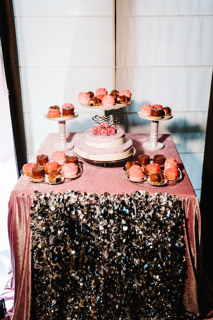 Torta di compleanno su una decorazione per feste di sfondo. Copia spazio. Concetto di celebrazione. Torta Alla Moda. Barretta di cioccolato. Tavolo con dolci, caramelle, dessert.