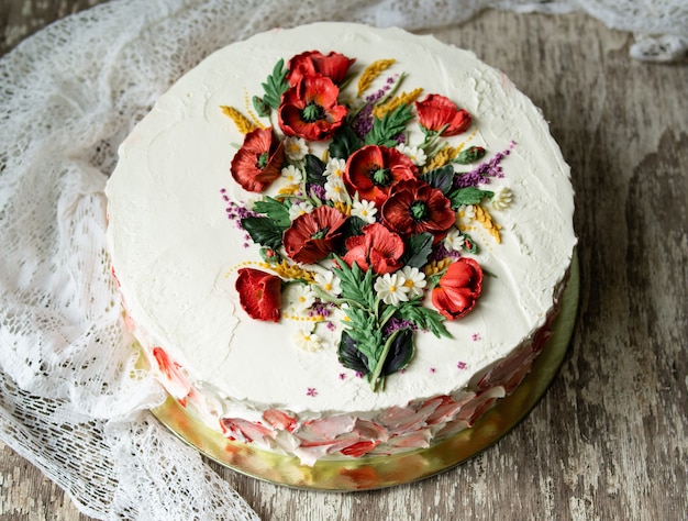 Torta di crema bianca decorata con fiori di crema di burro