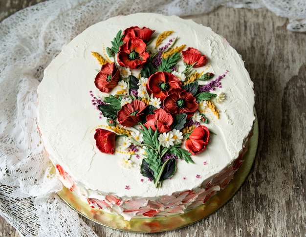 Torta di crema bianca decorata con fiori di crema di burro