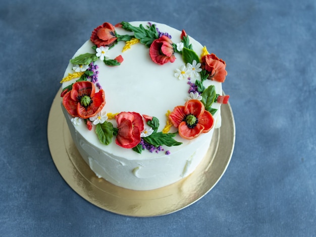 Torta di crema bianca decorata con fiori di crema di burro