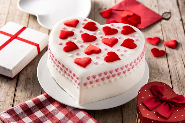 Torta di cuore per San Valentino, festa della mamma o compleanno, decorata con cuori di zucchero sulla tavola di legno