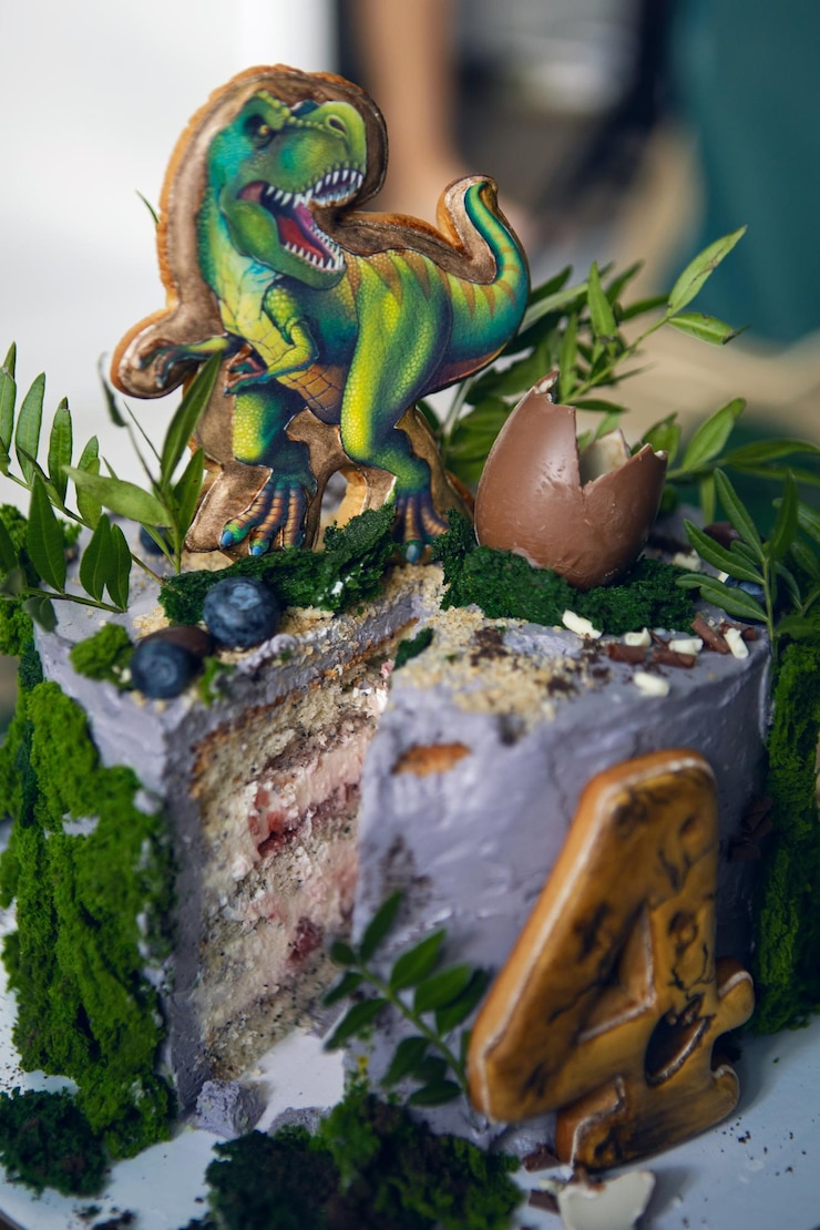 Foto torta di dinosauro verde per un bambino di quattro anni con muschio e uova