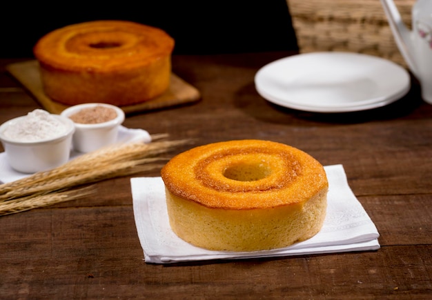 Torta di farina di frumento su legno con altra torta in background con ramo di grano accanto.