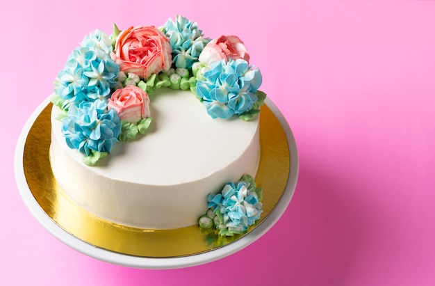 torta di fiori carino sul basamento della torta e sfondo rosa chiaro, vista dall&#39;alto