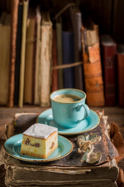 Torta di formaggio dolce e caffè sul libro in biblioteca