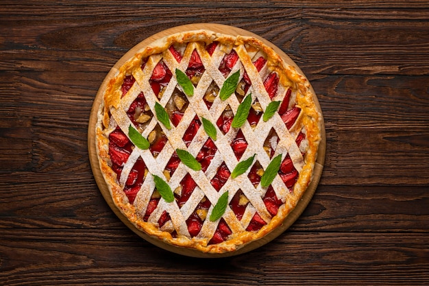 Torta di fragole al forno. Torta alle fragole. Torta aperta con fragole e banane su un tavolo di legno, vista dall'alto