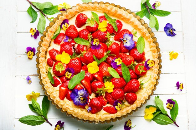 Torta di fragole decorata con foglie di menta e fiori