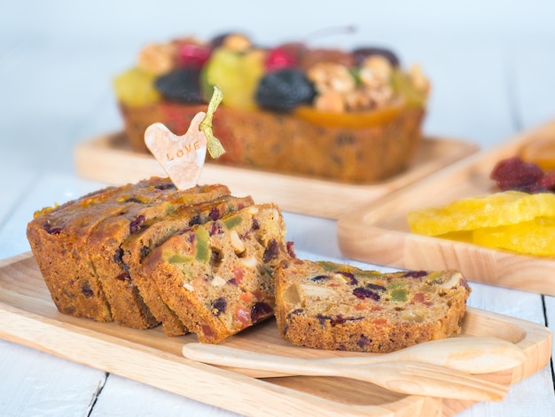 Torta di frutta a fette in piatto di legno con cucchiaio e forchetta di legno