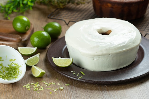 Torta di frutta al limone umida su piastra con fette di limone su tavola di legno Deliziosa colazione tradizionale tea time Ricetta della torta al limone