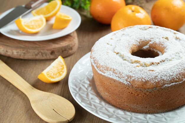 Torta di frutta arancione umida sul piatto con fette d'arancia sul tavolo di legno Deliziosa colazione tradizionale inglese tea time Ricetta della torta arancione