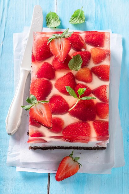 Torta di gelatina di fragole fatta in casa con uno strato fruttato circondato da gelatina