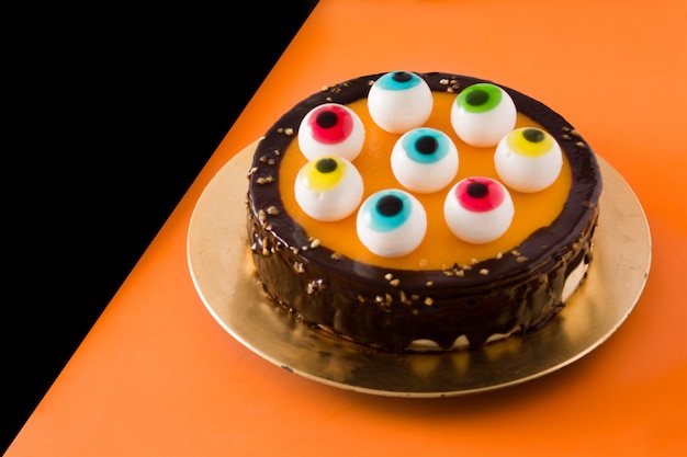 Torta di Halloween con la decorazione degli occhi di caramella sull'arancia e sul nero.