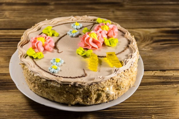 Torta di Kiev con panna, noci e meringa su tavola di legno