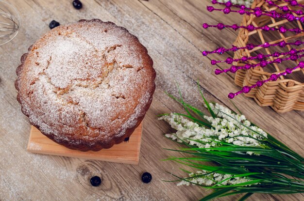 Torta di libbra su tavola di legno decorata con mirtilli intorno