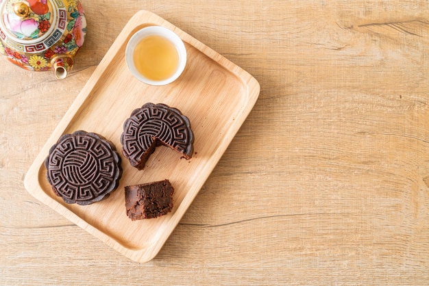 Torta di luna cinese al gusto di cioccolato fondente su piatto di legno