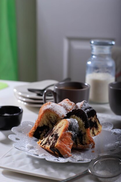 Torta di marmo con caffè con zucchero in polvere e utensili da cucina vintage, concetto di panetteria bianca