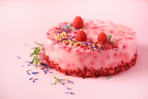 Torta di marmo rosa con lamponi, fiori secchi, rosmarino. Copia spazio per il tuo testo.