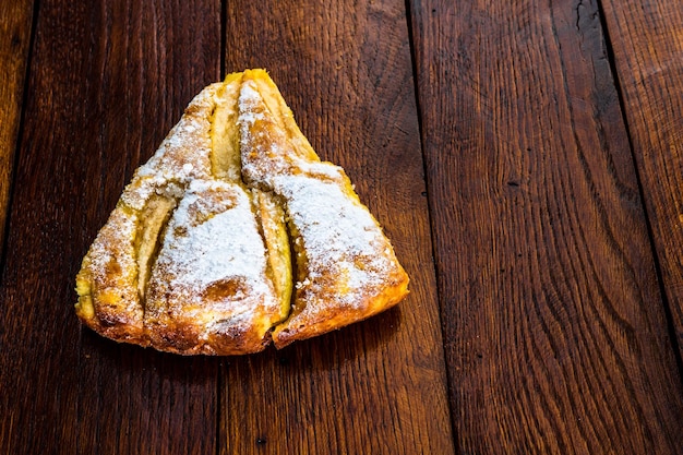 Torta di mele affettata con cannella su tavola di legno rustica