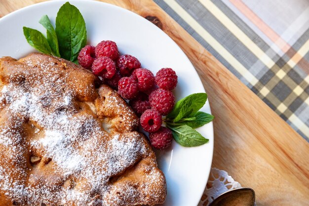 Torta di mele con lamponi freschi e menta su uno sfondo di legno Messa a fuoco selettiva mangiare sano