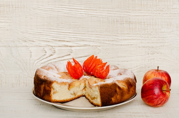 Torta di mele e mele mature su una superficie di legno chiaro, con spazio per il testo