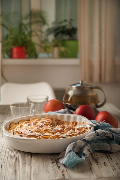 Torta di mele fatta in casa su un legno bianco vicino alla finestra