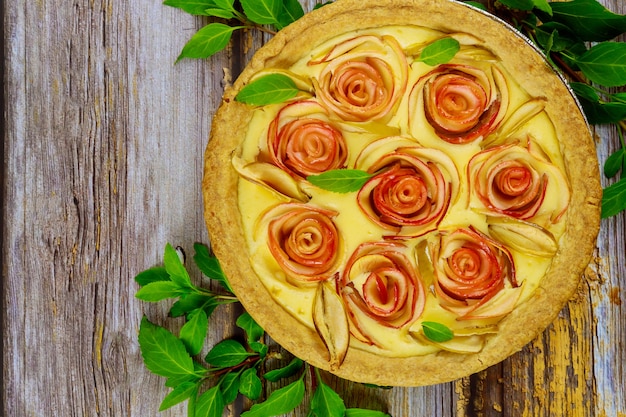 Torta di mele fresca con decorazione come una rosa su una superficie di legno. Vista dall'alto.