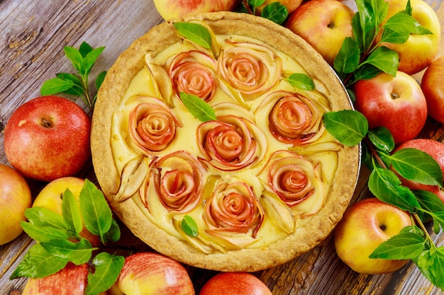 Torta di mele fresca con decorazioni come una rosa sulla tavola di legno. Vista dall'alto.