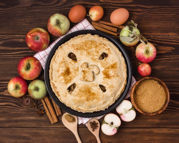 Torta di mele gustosa fatta in casa con mele e spezie Sfondo di legno Vista dall'alto Mele crude Bastoncini di cannella