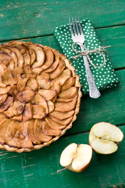 Torta di mele succosa con cannella e brandy su una tavola verde