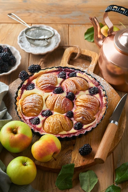 Torta di mele Torta di mele e more o torta decorata con zucchero a velo su vecchio tavolo di legno Delizioso dessert per la cena autunnale o invernale Dessert di pasticceria autunnale Soft focus