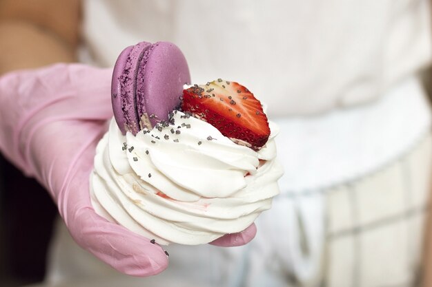 Torta di meringa, pasticcere che tiene una torta preparata nelle sue mani