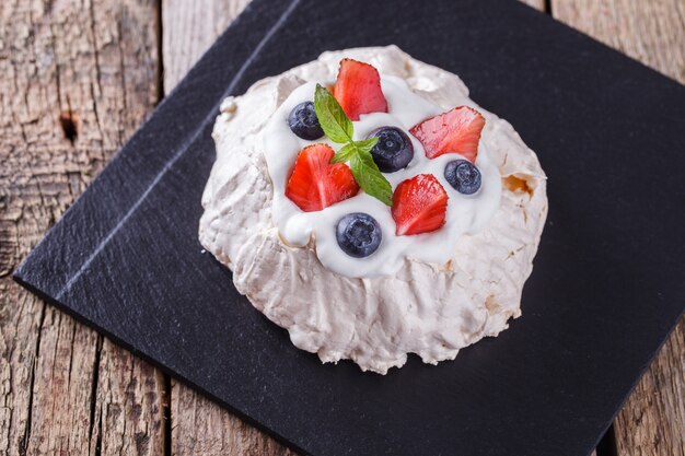 Torta di meringa Pavlova con crema e frutti di bosco