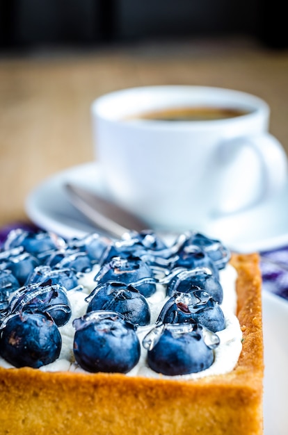 Torta di mirtilli da vicino con una tazza di caffè