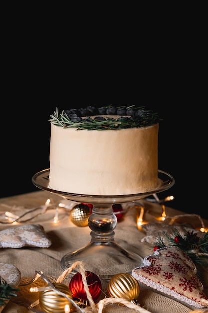 Torta di mirtilli rossi su sfondo nero con decorazioni natalizie.