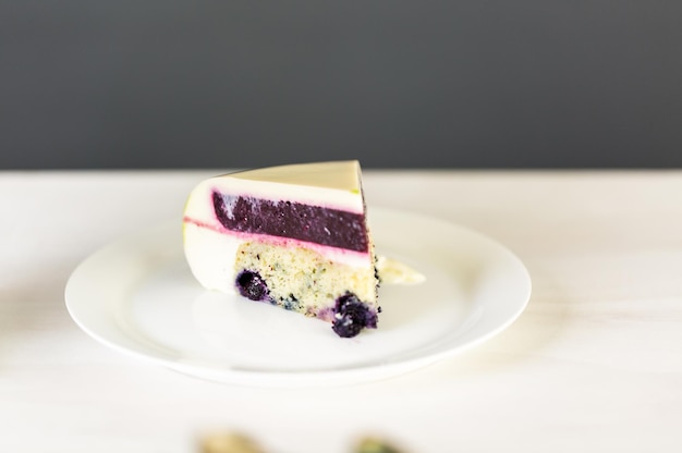 Torta di mousse a fette con glassa a specchio sul tavolo.