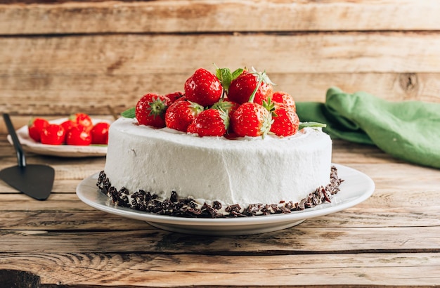 Torta di mousse al cioccolato intero con fragola e menta su fondo rustico in legno Fuoco selettivo