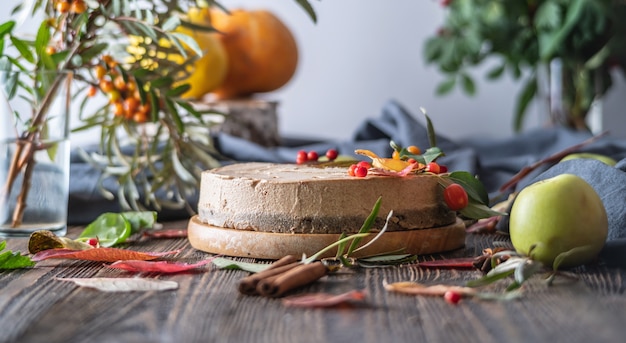 Torta di mousse marrone decorata con foglie autunnali e bacche