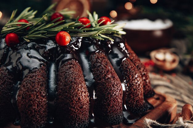 Torta di Natale al cioccolato decorata con frutti di bosco e rosmarino