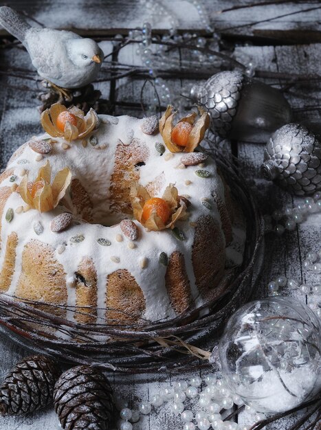 torta di natale con decorazioni invernali su fondo in legno chiaro.