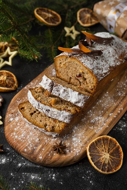 Torta di Natale con noci e frutta secca affettata su un tagliere