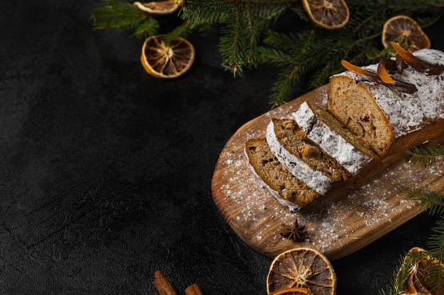 Torta di Natale con noci e frutta secca affettata su un tagliere