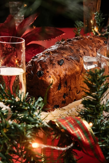 Torta di Natale con uvette e un bicchiere di champagne su uno sfondo rosso