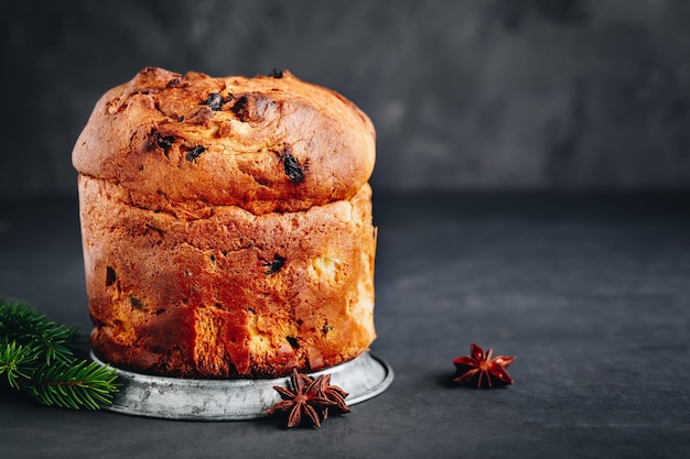 Torta di panettone Torta di Natale tradizionale italiana con frutta secca su fondo di pietra scuro con spazio per la copia