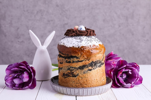 Torta di Pasqua e fiori su uno sfondo bianco di legno