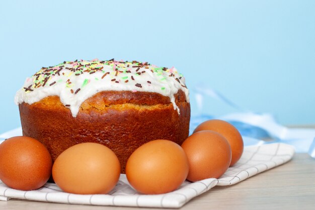 Torta di Pasqua e uova colorate su sfondo blu