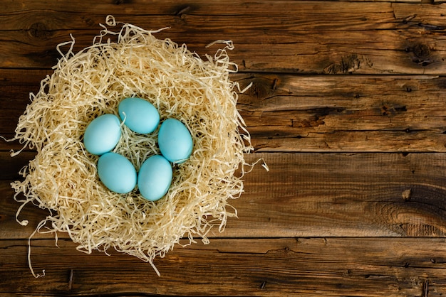 Torta di Pasqua e uova colorate su un tavolo di legno.