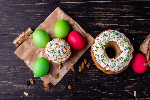 Torta di Pasqua e uova colorate su uno sfondo scuro